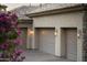 Three car garage with custom carriage doors and desert landscaping at 13249 E Summit Dr, Scottsdale, AZ 85259
