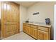 Functional laundry room with wood cabinets, granite countertops, and a stylish wood door at 13249 E Summit Dr, Scottsdale, AZ 85259