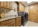 Spacious laundry room with custom cabinets, granite countertops, a sink, and modern appliances for convenience at 13249 E Summit Dr, Scottsdale, AZ 85259