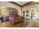 Elegant primary bedroom with wood floors, tray ceiling, archway, and luxurious ensuite bathroom at 13249 E Summit Dr, Scottsdale, AZ 85259