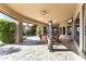 Beautiful covered patio features stone flooring, ceiling fan, and views of the lush backyard at 13249 E Summit Dr, Scottsdale, AZ 85259