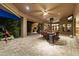 Large covered patio provides ample space for entertaining, featuring an outdoor dining set and lush landscaping at 13249 E Summit Dr, Scottsdale, AZ 85259