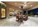 Outdoor patio with dining table and heat lamps, plus clear views into the living room through a large picture window at 13249 E Summit Dr, Scottsdale, AZ 85259