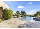 Stunning backyard pool with lush landscaping, rock waterfall, and picturesque desert scenery at 13249 E Summit Dr, Scottsdale, AZ 85259