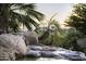 Close-up of rock waterfall cascading into a sparkling pool, surrounded by palm trees and desert landscaping at 13249 E Summit Dr, Scottsdale, AZ 85259