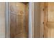 Walk-in shower with travertine walls and floor and a glass door and a shower head at 13249 E Summit Dr, Scottsdale, AZ 85259
