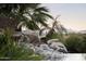 Water feature cascades into the pool with scenic mountain views beyond the landscaped backyard at 13249 E Summit Dr, Scottsdale, AZ 85259
