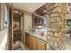 Custom wet bar featuring stone accents, wine storage, and a granite countertop, perfect for entertaining guests at 13249 E Summit Dr, Scottsdale, AZ 85259