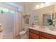 Bathroom with a single sink vanity, framed mirror, and shower-tub combo with a shower curtain at 15353 W Cheery Lynn Rd, Goodyear, AZ 85395