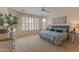 Bright bedroom featuring large windows, a ceiling fan, a queen bed, and neutral decor for a relaxing atmosphere at 15353 W Cheery Lynn Rd, Goodyear, AZ 85395