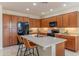 Modern kitchen with wood cabinets, stainless steel appliances, and large island with bar seating at 15353 W Cheery Lynn Rd, Goodyear, AZ 85395