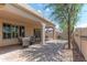 A covered patio, surrounded by a backyard with outdoor dining and seating furniture at 15353 W Cheery Lynn Rd, Goodyear, AZ 85395