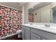 Bright bathroom featuring double sinks, neutral walls, and a colorful patterned shower curtain at 1647 W Gold Mine Way, San Tan Valley, AZ 85144