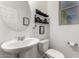 Charming powder room with pedestal sink, decorative shelving and modern fixtures at 1647 W Gold Mine Way, San Tan Valley, AZ 85144