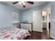 Cozy bedroom featuring light blue walls, wood floors, and a bathroom, with a seashell patterned bedspread at 1647 W Gold Mine Way, San Tan Valley, AZ 85144