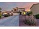 Two-story home featuring neutral tones, an attached two-car garage, and a well-maintained front yard at dusk at 1647 W Gold Mine Way, San Tan Valley, AZ 85144
