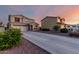 A suburban two-story home with a long driveway and well-maintained landscaping under a twilight sky at 1647 W Gold Mine Way, San Tan Valley, AZ 85144