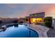 Inviting backyard with pool, stone patio, and covered patio for relaxing and entertaining at 1647 W Gold Mine Way, San Tan Valley, AZ 85144