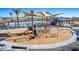 Community playground with a slide, climbing equipment, shade structures, and a view of the community pool at 16963 W Poinsettia Dr, Surprise, AZ 85388