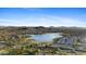 Beautiful aerial view of the neighborhood and a tranquil lake surrounded by mountains, offering a serene escape at 18387 W Mountain Sky Ave, Goodyear, AZ 85338
