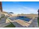 Backyard pool area with travertine deck, artificial grass, spa, outdoor seating area and desert landscaping at 18387 W Mountain Sky Ave, Goodyear, AZ 85338