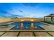 Relaxing backyard pool with fire feature, travertine tile, and desert landscaping under an evening sky at 18387 W Mountain Sky Ave, Goodyear, AZ 85338