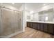 Bright bathroom features a spacious glass shower and double vanity with wood-look tile floors at 18522 W Mohave St, Goodyear, AZ 85338