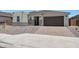 Charming single-story home with a desert landscape, brick driveway, and a two car garage at 18522 W Mohave St, Goodyear, AZ 85338