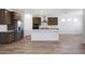 Bright and airy kitchen boasts a large central island, stainless appliances, and stylish wood floors at 18522 W Mohave St, Goodyear, AZ 85338