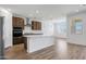Open kitchen featuring modern stainless steel appliances, light countertops, and wood-look flooring at 18522 W Mohave St, Goodyear, AZ 85338