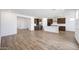 Large open-concept space with wood flooring, light walls, and kitchen view at 18522 W Mohave St, Goodyear, AZ 85338