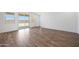 Spacious room with wood flooring, neutral wall color, and sliding glass door to backyard at 18522 W Mohave St, Goodyear, AZ 85338
