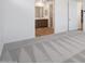 Carpeted bedroom showing access to attached ensuite bathroom with a door to the right at 18522 W Mohave St, Goodyear, AZ 85338