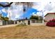 View of backyard and exterior of home; has an unfinished lawn, privacy fence, and small decorative trees at 2501 E Campbell Ave, Phoenix, AZ 85016