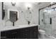 Modern bathroom with double vanity, dual round mirrors, and marble tiled walls at 2717 N 107Th Dr, Avondale, AZ 85392
