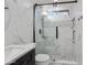 Luxurious bathroom with walk-in shower, marble tile, and dark vanity at 2717 N 107Th Dr, Avondale, AZ 85392
