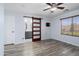 Bright bedroom with light wood floors, a wooden sliding door to bathroom and a window overlooking backyard at 2717 N 107Th Dr, Avondale, AZ 85392