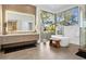 Bright bathroom with a soaking tub, large window, and double vanity at 28754 N 107Th St, Scottsdale, AZ 85262