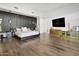 Modern bedroom with wood flooring, stylish accent wall, and a large TV at 28754 N 107Th St, Scottsdale, AZ 85262