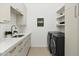 Well-lit laundry room with modern appliances, countertops, and storage shelves at 28754 N 107Th St, Scottsdale, AZ 85262