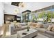 Bright, open living area featuring a glass-enclosed wine cellar, modern chandeliers, and seamless flow to the kitchen at 28754 N 107Th St, Scottsdale, AZ 85262