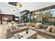 Open-concept living room with a wine cellar, modern chandeliers, comfortable seating, and expansive windows at 28754 N 107Th St, Scottsdale, AZ 85262