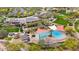 Aerial view of community pool with lounge seating, umbrellas, jacuzzi, and mature landscaping at 29344 N 132Nd Ln, Peoria, AZ 85383