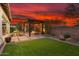 Lush backyard featuring an outdoor pergola with a fire pit, manicured lawn, and desert landscaping at 29344 N 132Nd Ln, Peoria, AZ 85383