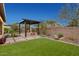 Beautiful backyard with a pergola-covered fire pit, desert landscaping, and a well-maintained lawn at 29344 N 132Nd Ln, Peoria, AZ 85383