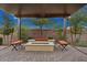 Charming pergola-covered fire pit area, complete with comfortable seating and lush landscaping at 29344 N 132Nd Ln, Peoria, AZ 85383
