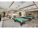 Community game room featuring multiple pool tables, a stone fireplace, and comfortable seating at 29344 N 132Nd Ln, Peoria, AZ 85383