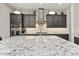 Modern kitchen featuring a large island with granite countertops, dark cabinets, and stainless steel appliances at 29344 N 132Nd Ln, Peoria, AZ 85383