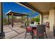 Inviting outdoor patio with a dining table and seating area, plus a stone fire pit under a pergola at 29344 N 132Nd Ln, Peoria, AZ 85383