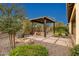 Relaxing outdoor patio featuring a fire pit under a pergola surrounded by desert landscaping at 29344 N 132Nd Ln, Peoria, AZ 85383